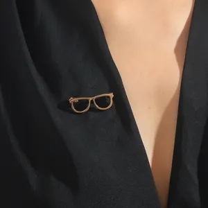 Close-up detail showcasing the delicate gold-colored glasses frame brooch pin texture.