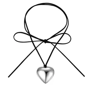 Vue détaillée du pendentif cœur bombé argenté avec beau collier en cordon de velours noir.