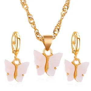 Goudkleurige ketting en oorbellen set met elegante witte acryl vlinderhangers voor dames.