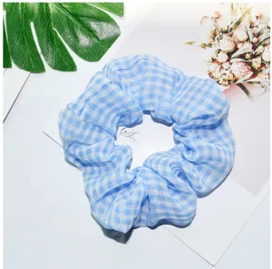 Blauw wit geruite mesh haarscrunchie detailweergave, zachte haaraccessoire voor dagelijks.