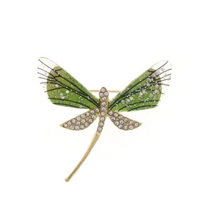 Detail shot of green acrylic dragonfly brooch with sparkling rhinestones and gold-tone finish.