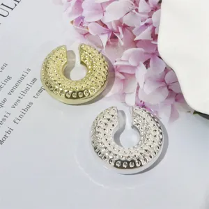 Detailansicht trendiger metallischer gehämmerter Ohrklemmen in Gold und Silber, Clip-Design.