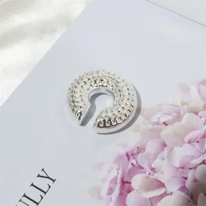 Silberne gehämmerte Ohrklemme im Detail, stylischer Ohrring ohne Piercing für den Alltag.