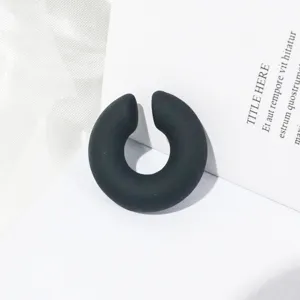 Dettaglio di orecchino a clip C nero opaco chuncky, orecchino minimalista senza foro.