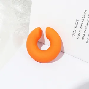 Dettaglio polsino orecchio a C chunky opaco arancione, gioielli in acrilico minimalisti.