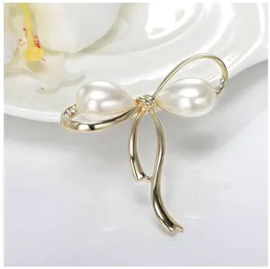 Goldfarbene Schleifen-Brosche Detail, elegante Perlen- und Kristall-Schmuckaccessoire.