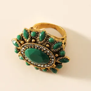 Vue détaillée d'une bague vintage rétro avec une pierre verte et métal bronze.