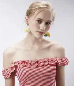 Gedetailleerd overzicht van schattige mango vorm acryl oorbellen gedragen door het model.