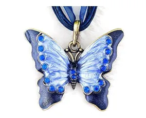 Detailopname van een vintage vlinderhanger van legering met blauwe emaille en strass-steentjes.