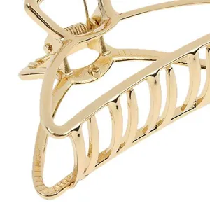 Detalle de pinza de pelo geométrica hueca de metal dorado, accesorio diario elegante.