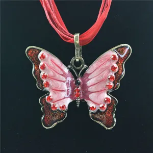 Vintage vlinder hanger ketting met roze emaille en rode strass steentjes. Detailweergave.
