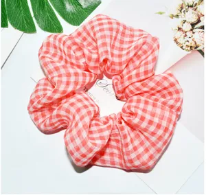 Detail van rood-witte geruite chiffon scrunchie, lichtgewicht haaraccessoire voor vrouwen.