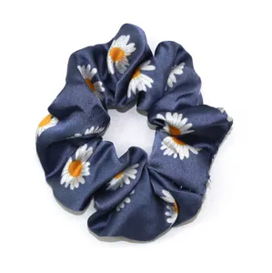 Blauwe satijn madeliefje print haarscrunchie gedetailleerd overzicht stoffen haarband