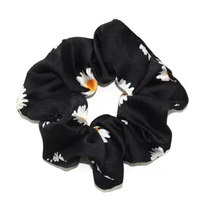 Zwarte stoffen haarscrunchie met schattige witte madeliefjesprint, stijlvol elastisch haarelastiek.