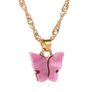 Gedetailleerd overzicht van een goudkleurige ketting met roze acryl vlinderhanger.