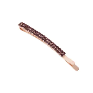 Detailopname van een roségouden haarschuifje met dubbele strass-steentjes, haaraccessoire.