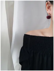 Gedetailleerd overzicht van schattige bordeauxrode pluche pompon oorbellen, zachte winters sieraden.