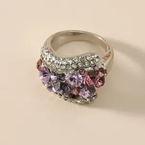 Gedetailleerde close-up van een opvallende ring met schitterende paarse strass steentjes.
