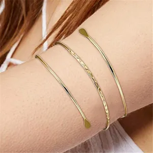 Bracciale rigido multistrato dorato in dettaglio, elegante polsino aperto stile punk.