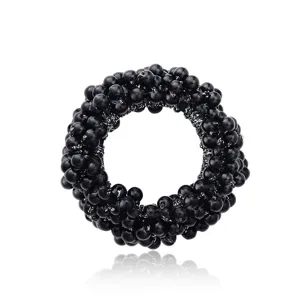 Dettaglio dell'elastico per capelli con perle nere, accessorio elegante per donne.