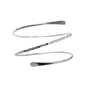Primo piano del bracciale a spirale in argento con dettaglio di texture martellata e design aperto.