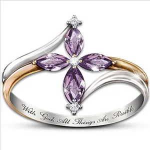 Gedetailleerde close-up van de paarse markies zirconia kruisring met tweekleurige band.