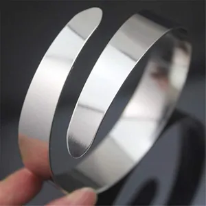 Gedetailleerd overzicht van een minimalistische glanzende metalen brede armarmband.