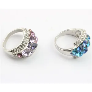 Gedetailleerde close-up van twee brede zilveren moderingen met kleurrijke strass-steentjes.