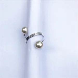 Primo piano dettagliato di un portatovaglioli a molla con perle minimalista e argento.