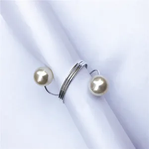 Dettaglio portatovagliolo con perla e molla, elegante decorazione tavola in filo metallico.
