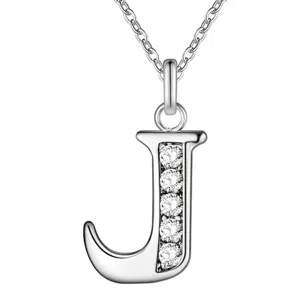 Detailopname van zilveren letter J hanger halsketting met glinsterende kristalstenen.