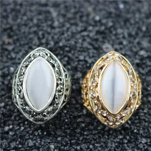 Close-up van vintage holle tak kattenoog ringen in zilver en goud met sprankelende stenen.