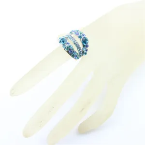 Gedetailleerd overzicht van een meerlaagse strass ring met fonkelende blauwe en paarse kristallen.