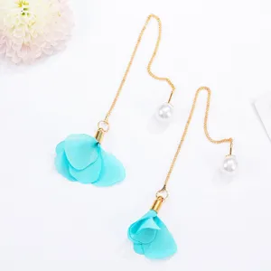 Detailed close-up of elegant long tassel earrings featuring blue fabric flower petals and white pearls.
