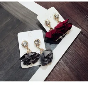 Detailed close-up view of elegant fabric flower rhinestone tassel earrings in wine red and grey.