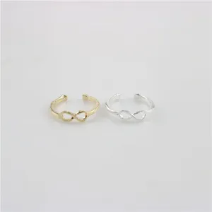 Vista detallada en primer plano de los anillos de metal símbolo infinito oro y plata.