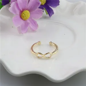 Primer plano detallado del anillo de dedo y pie ajustable de metal dorado con símbolo de infinito.