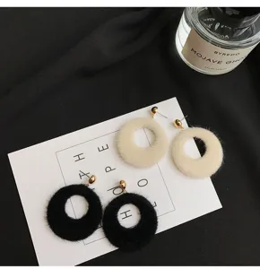 Pluizige ronde pluche oorbellen met zacht nepbont ringontwerp. Gezellige gedetailleerde weergave.