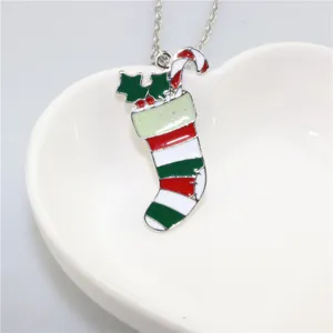 Detailopname van de kerstsok hanger halsketting op een witte hartvormige schaal voor feestdagen.