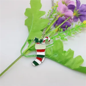 Detailopname van kerstsok hanger ketting, met weergave van het geëmailleerde rood-groene ontwerp.