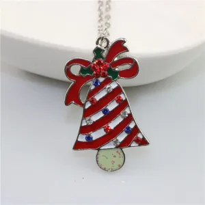 Close-up detail van de kerstbel hanger ketting met rode strik en kleurrijke strass steentjes.