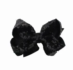 Detailweergave van een zwarte pailletten strik haarspeld, glinsterend feestelijk haaraccessoire.