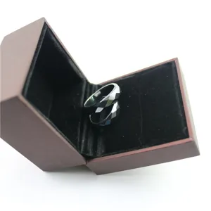 Close up detail view of black faceted magnetic rings displayed inside a brown velvet jewelry box.