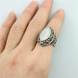 Vintage zilverkleurige ring met een witte opale markiessteen en sierlijk takontwerp.