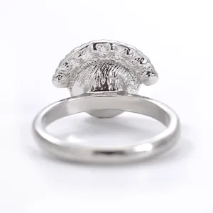 Detailopname van de zilveren metalen ringachterkant met gesneden textuur en gladde gepolijste band.