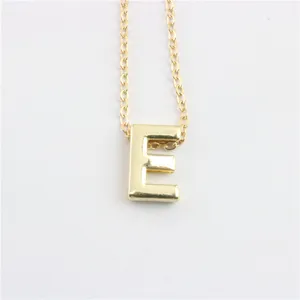 Gedetailleerde close-up van de minimalistische gouden letter E hanger aan een fijne ketting.