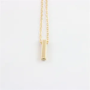 Gedetailleerde close-up van een minimalistische gouden staaf hanger halsketting, stijlvol.