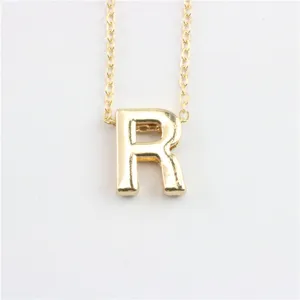 Close-up van gouden letter R hanger ketting, delicate ketting details van initialen.