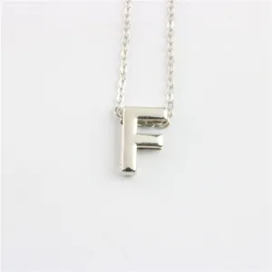 Gedetailleerde opname van de zilveren letter F hanger ketting met fijne metalen ketting.