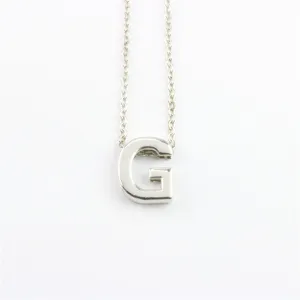 Detailopname van een zilveren letter G hanger ketting met fijne ketting, minimalistisch design.